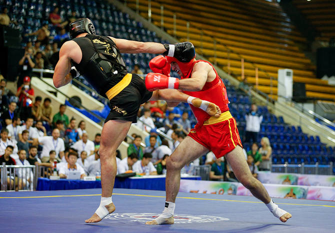A fighter landing a kick at a Sanda tournament