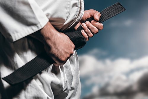 Karate student holding his black belt