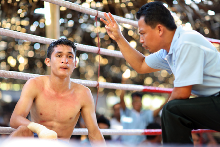 Lethwei fighter being counted out in the ring by the referee