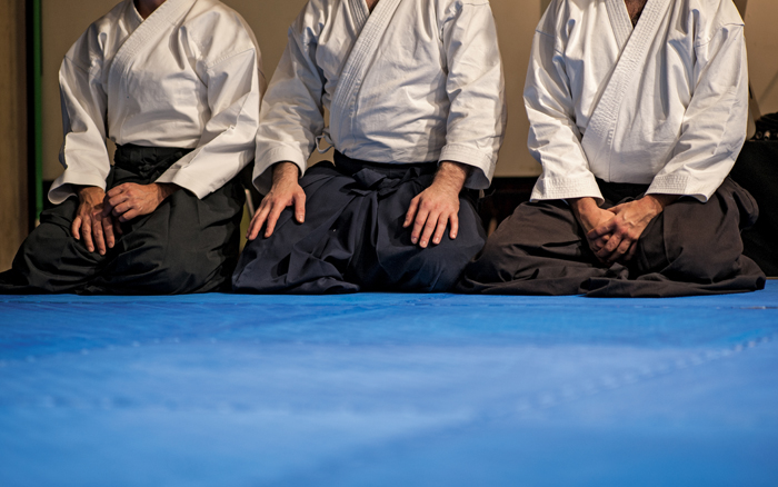 Aikido practitioners sitting on the mat in the dojo