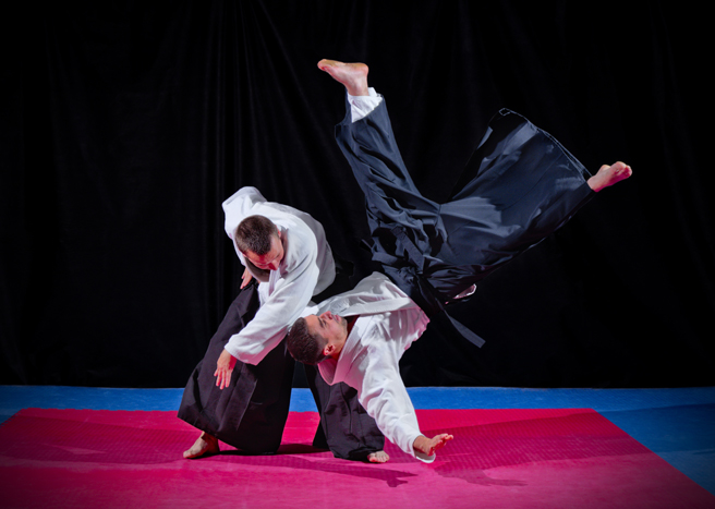 Aikido practitioners performing a technique on the mats