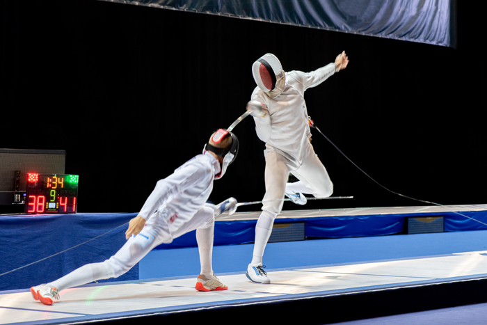 Two fencers competing at a fencing competition