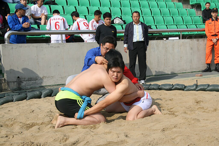 Two Ssireum wrestlers in the kneeling position getting ready for a match