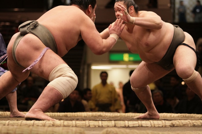 Sumo wrestlers fighting in the Dohyo