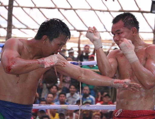 This is a photograph of two Lethwei fighters competing against each other in the ring