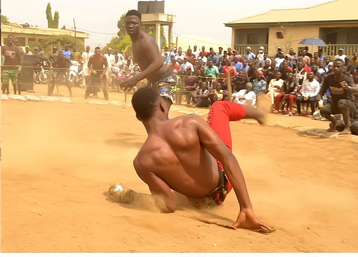 A Dambe fight taking place with one fighter being knocked down