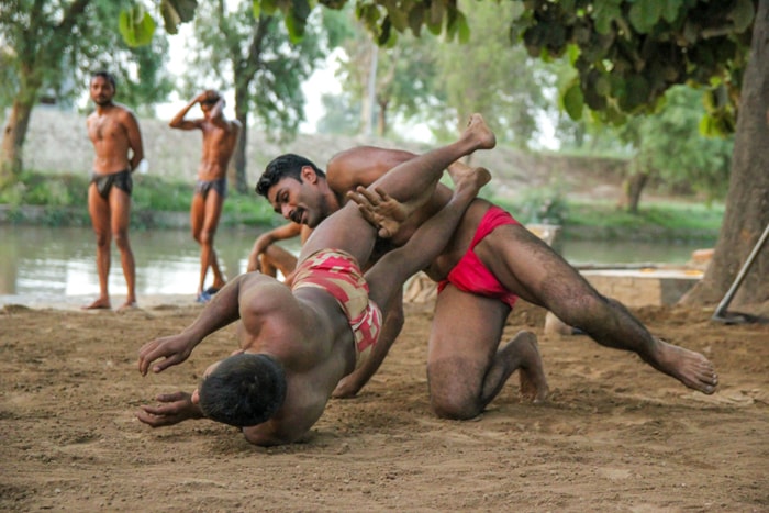 Mud wrestling training with two men practicing